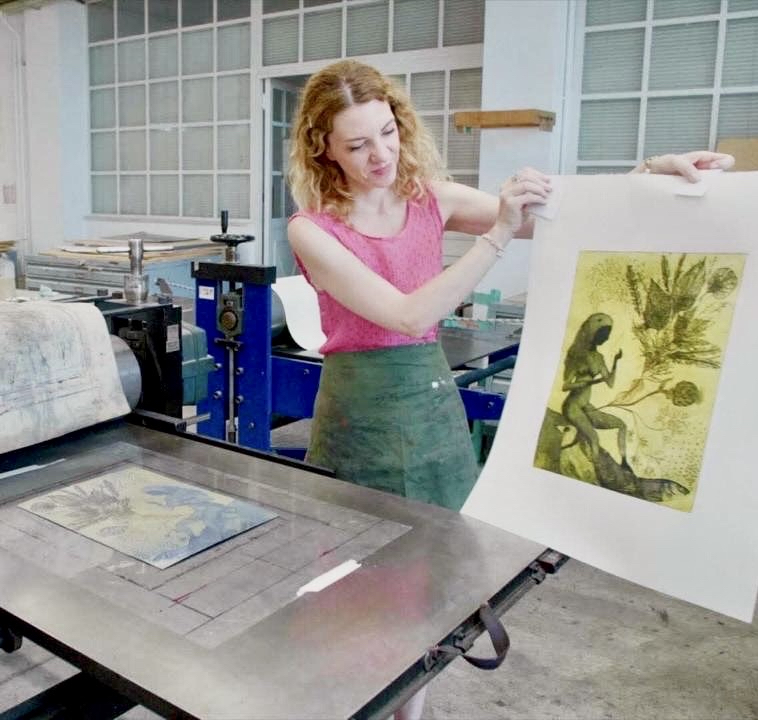 Anna Charaktinou holding a print beside an etching press