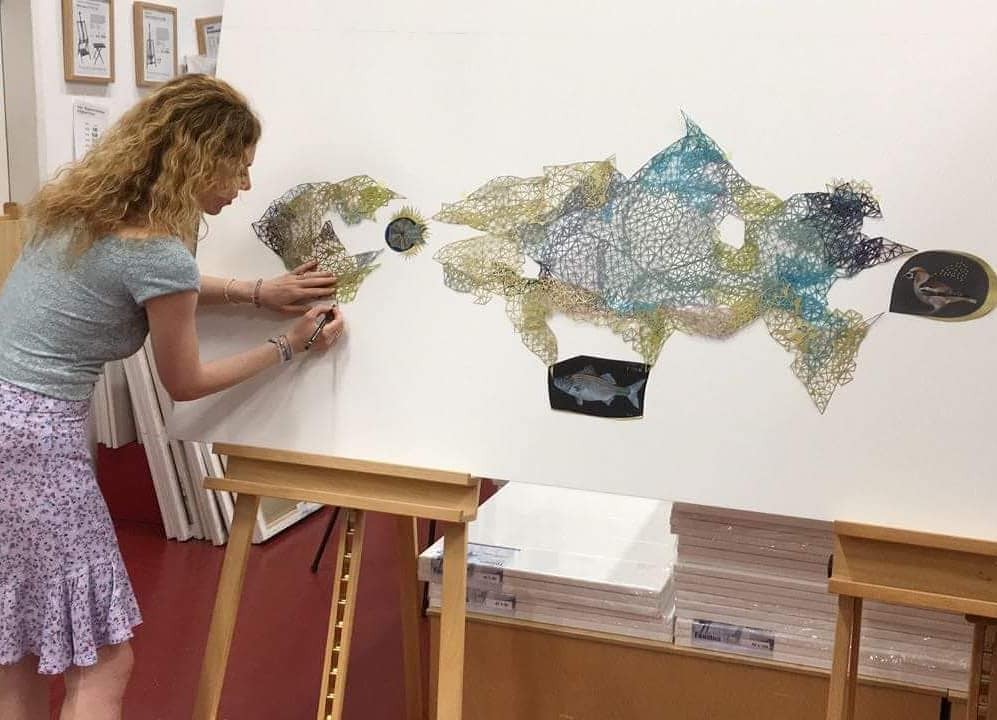 Anna Charaktinou assembling a large geometric paper installation