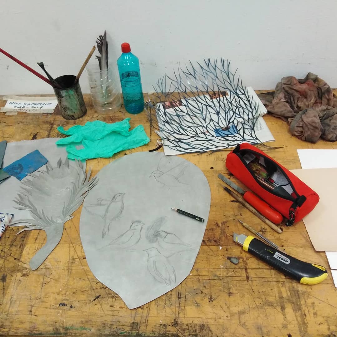 Anna Charaktinou's worktable with drawings, cut paper and tools